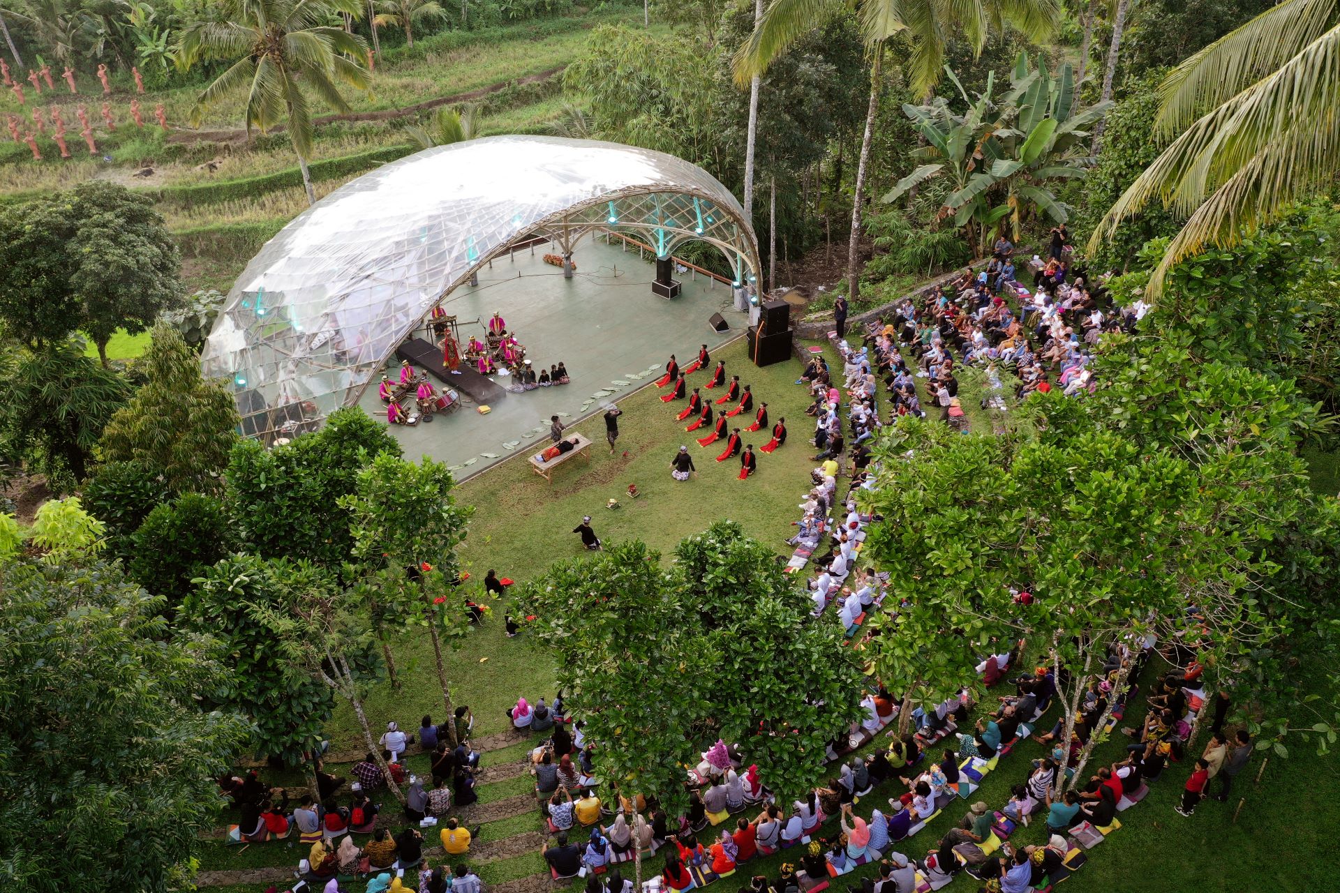 Patung penari Gandrung terakota di tengah hamparan sawah