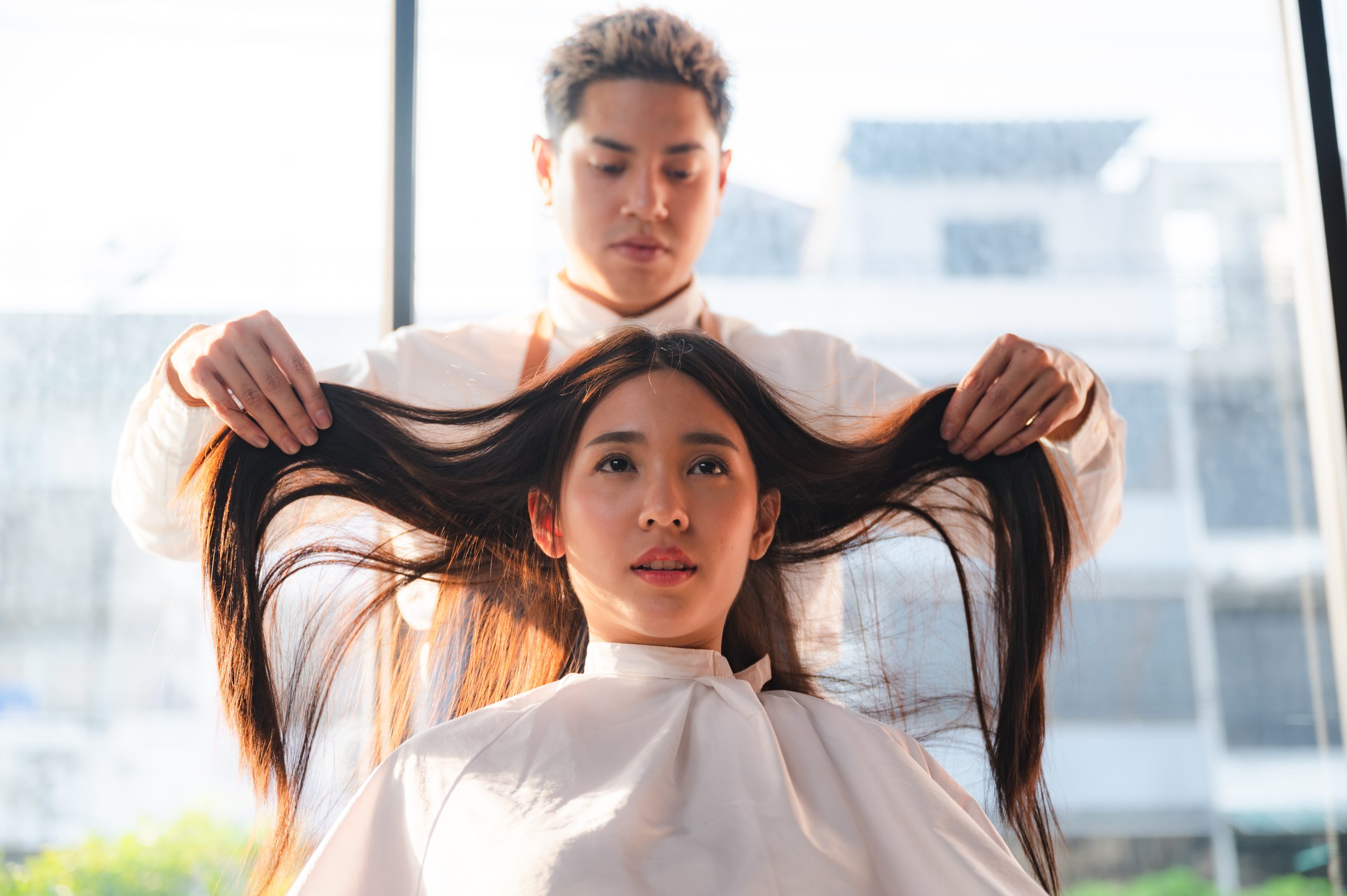 hairdresser and beautiful client woman making treatment hair health care in fashion style salon