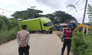 Truk Box Muatan Air Mineral Terperosok di Jalan Gandus, Arus Lalu Lintas Tersendat