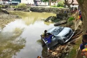 Terinjak Gas, Mobil Sigra Daihatsu Nyemplung di Anak Sungai Musi Palembang.